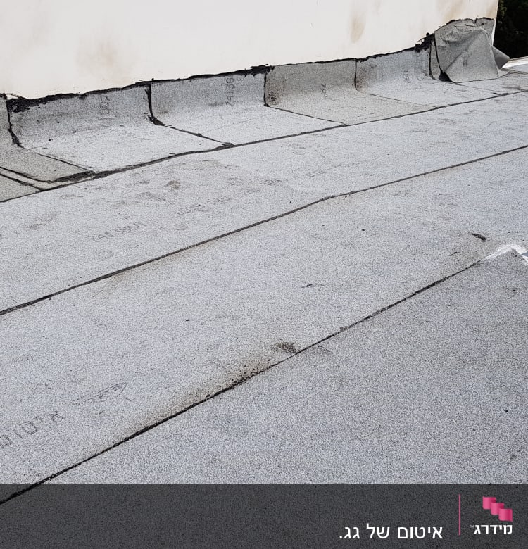 גג אטום ביריעות ביטומניות אפורות עם חיבורים שחורים